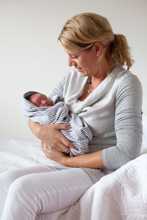 Verloskundige met een pasgeboren baby in een doek